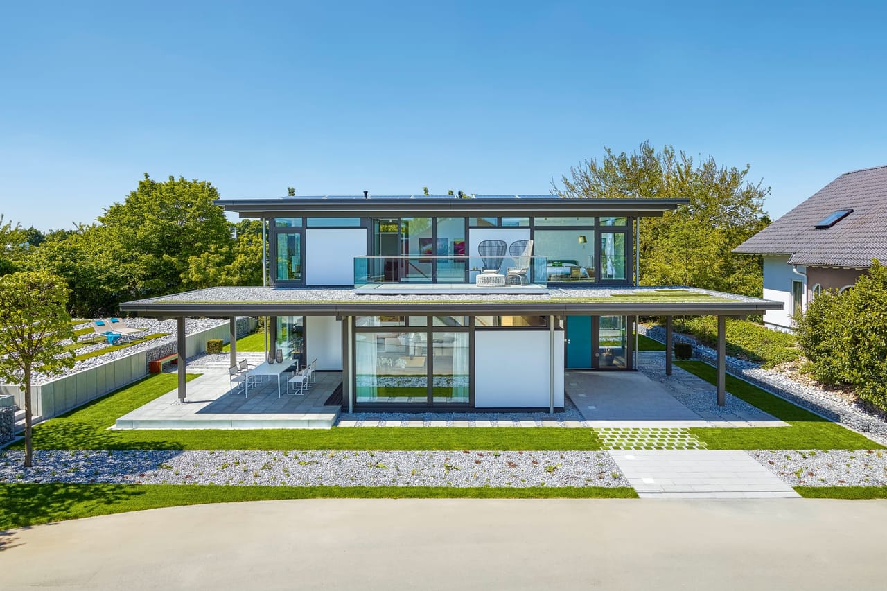 Modernes Wohnhaus mit Glasfassade und Gartenanlage